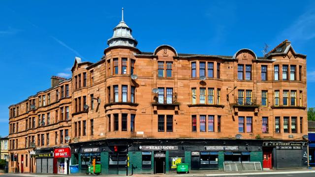 A splayed red sandstone Glasgow style corner tenement.