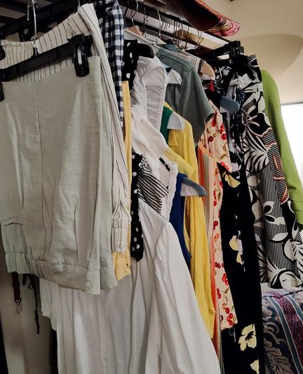 A bunch of summer clothes hanging up. Undifferentiated riot of color. Red! Yellow! Lime green! Cherries, polka dots, flowers! No restraint!