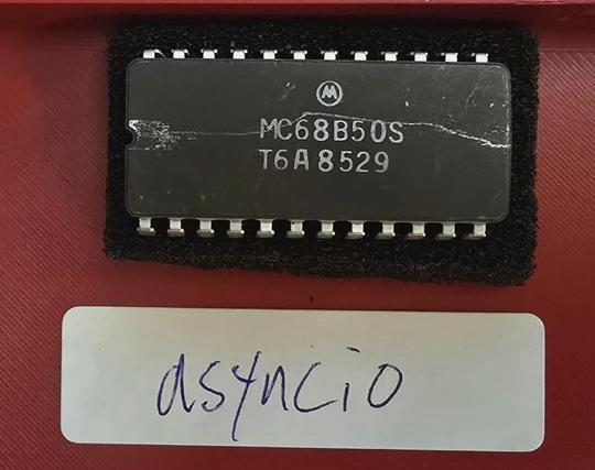 MC68B50S IC and a handwritten label reading asyncio
