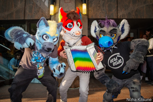 three fursuiters pose for a photo, Keys with a rainbow accordion flanked by two hyenas