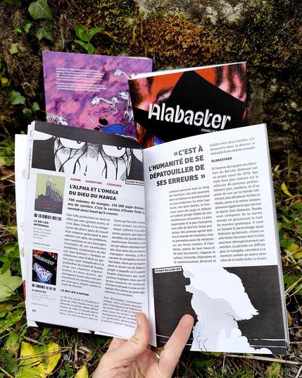 Photo de la double page du magazine "Zoo manga" d'avril-mai 2025 avec le titre "L'alpha et l'omega du Dieu du manga" et des images extraites des livres de Tezuka Alabaster et le roi Léo