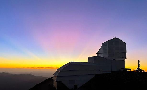 A colorful blue and pink sunset sky above Vera C. Rubin Observatory at its home on Cerro Pachón in Chile.
