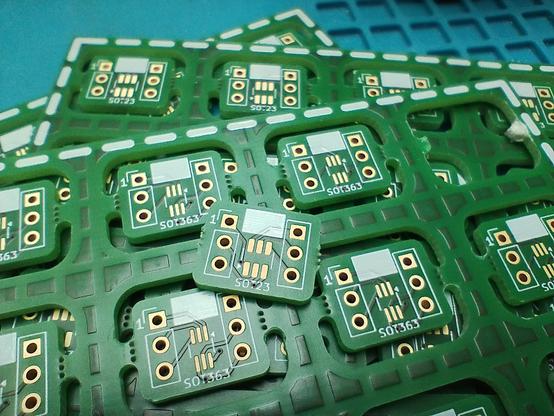 the delivered boards, they came in panels of 20 each. You can see both sides, one of the individual boards has been broken out of the panel and lies above them with SOT23 side up, the panel beneath has SOT363 side up. the next panel below has SOT23 up, but is only partially visible at the top.
