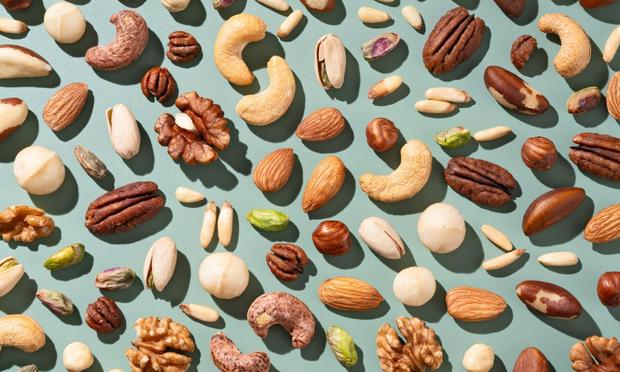Varios frutos secos sobre fondo azul. (Getty Images)