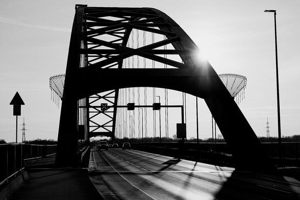 View of the steel structure of an arch bridge with car traffic