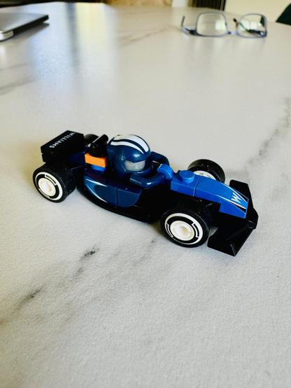 Minifigure style Formula 1 car. Just 29 pieces. 
In the background a pair of glasses