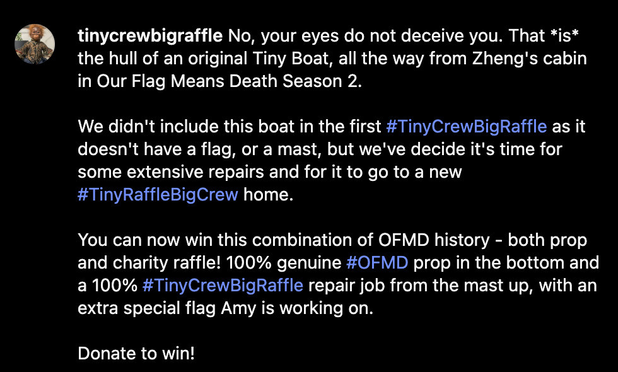 Instagram post caption from @ TinyCrewBigRaffle: “No, your eyes do not deceive you. That *is* the hull of an original Tiny Boat, all the way from Zheng's cabin in Our Flag Means Death Season 2. We didn't include this boat in the first # TinyCrewBigRaffle as it doesn't have a flag, or a mast, but we've decided it's time for some extensive repairs and for it to go to a new # TinyRaffleBigCrew home. You can now win this combination of OFMD history - both prop and charity raffle! 100% genuine OFMD prop in the bottom and a 100% Tiny Crew Big Raffle repair job from the mast up, with an extra special flag Amy is working on. Donate to win!”