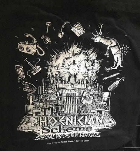 das bild zeigt einen weißen siebdruck auf schwarzer stofftasche, der titel des comic-designs ist "The Phoenician Scheme"