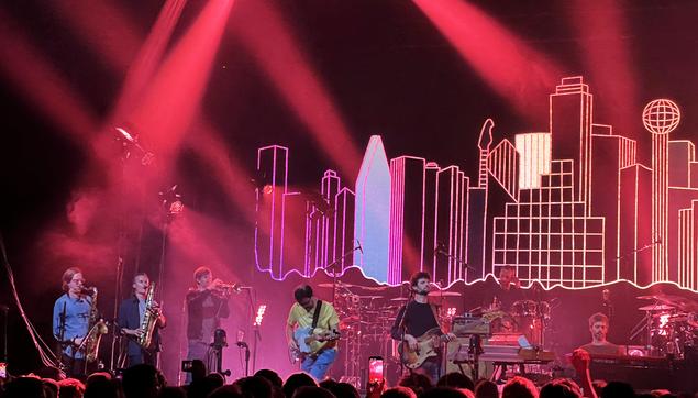 Some of the guys in the band on stage with the "Empire Central" cover design as their backdrop.