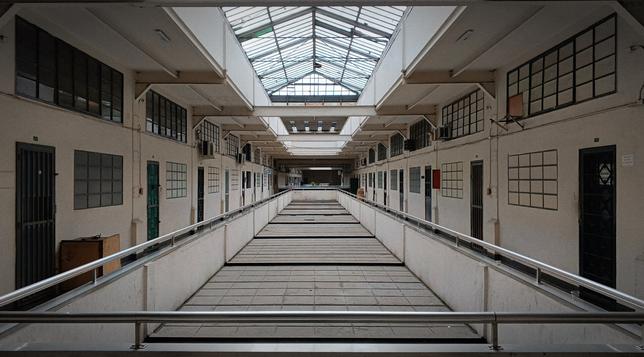 A photo of a run down and dusty office/commercial building, with a large ceiling window up top.