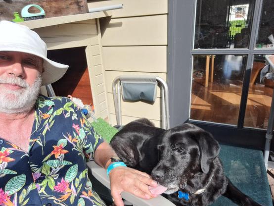 Selfie with my dog relaxing in the sun with his tongue between my fingers.