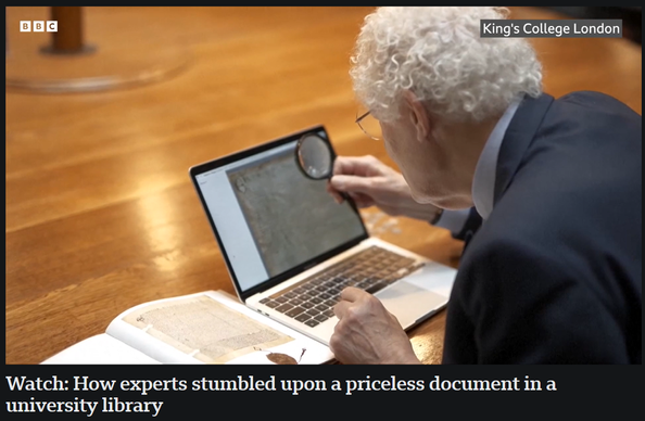 A grey haired man crouches over a laptop peering at the screen through a magnifying glass. On the desk to the left a book lies open at a page with an illustration similar to that being displayed on the laptop.

An inset tells us the location is King's College, London.

The caption reads "Watch: How experts stumbled upon a priceless document in a university library"