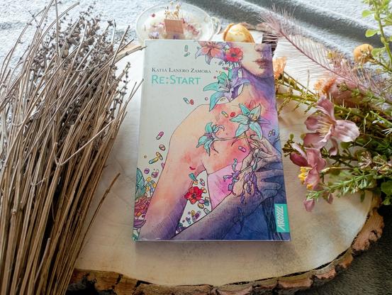 Une photo du livre Re:Start de Katia Lanero Zamora entouré d’objets de décoration.