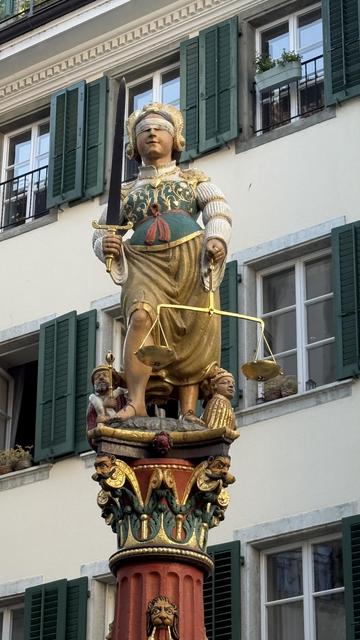 The Fountain of Justice ("Gerechtigkeitsbrunnen") in Solothurn. It shows the statue of the goddes Justice, holding a sword and a scale. Her eyes are blindfolded. She stands above the four figures of Prudentia, Fortitudo, Temperantia and Justitia.