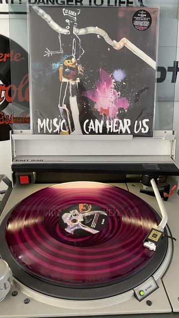 Vinyl LP „ DJ Koze - Music Can Hear Us“ auf einem Plattenspieler. Das Vinyl ist in der Farbe Magenta.