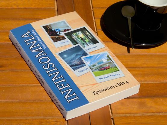 Ein Paperback-Buch, dekorativ abgelegt auf einem Cafétisch. Auf dem Cover ist ein breiter blauer Streifen, auf dem "INFINISOMNIA" steht. Daneben sind vier Sofortbilder auf einem Holzuntergrund dargestellt. Auf den Sofortbildern sind die Coverfotos der einzelnen Episoden abgebildet. Darunter der Text "Episoden 1 bis 4".