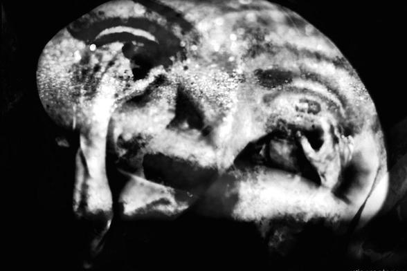 Black and white photo, landscape format, multiple exposure. Self-portrait. A person's bent body, barely recognizable, dark and creased, head not visible. This photo is double-exposed with the same photo mirrored. The overall shape resembles a face. Through additional exposure with the face of a stone sculpture, of which the eyes are particularly clearly visible, the overall image appears as if the person's arms are holding the lower eyelids open, pulling them downward. The overall impression is surreal, ranging from sad to frightening.