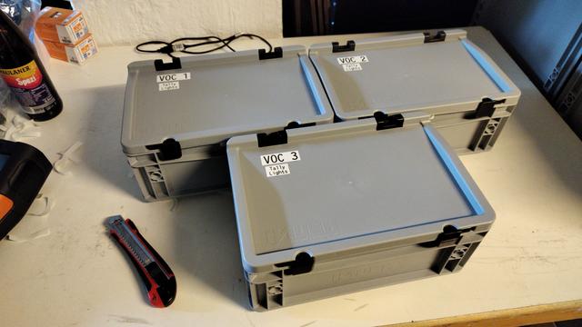 Drei kleine Eurokisten, beschriftet mit "VOC 1" und "Tally Lights"