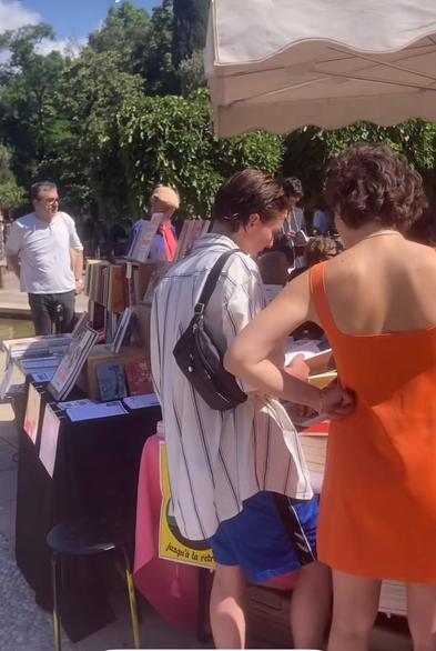 Photo de personnes dehors, au soleil, au FLIP à Marseille. On aperçoit notre stand derrière les visiteureuses.