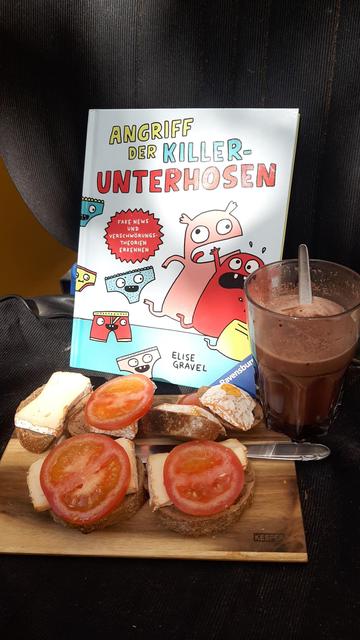 Kinderbuch 
Angriff der killerunterhosen mit vesperbrett und tomatenkäse Broten und ein Glas Kakao auf einem Sessel in der schattigen sonne