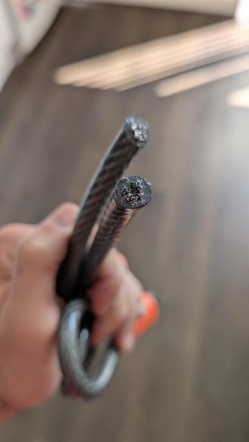 The closeup view of a bicycle lock cable cleanly cut out.