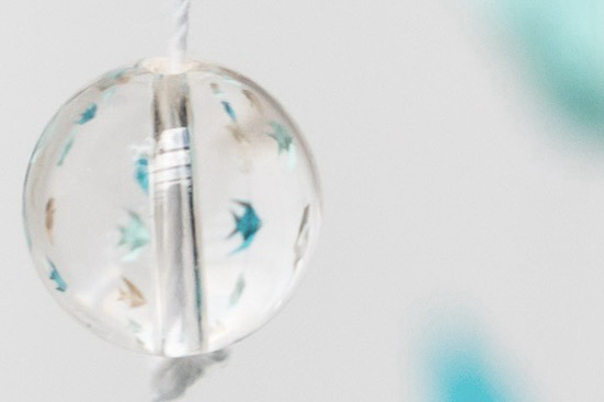 Perle dans laquelle se reflètent des poissons turquoises en origami