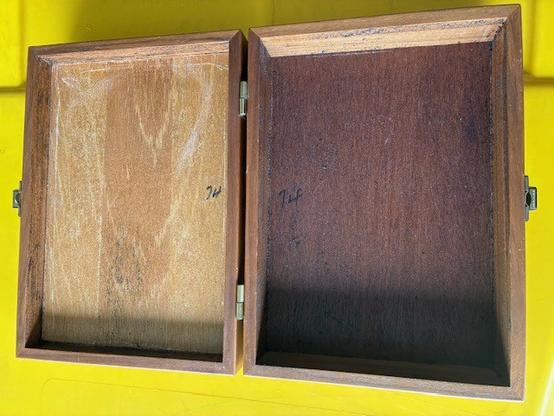 Photo of the inside of the wooden case, showing gritty residue from the foam that fell-to-pieces/sticky-clumps within. This residue is difficult to remove (without knowing proper materials/technique).