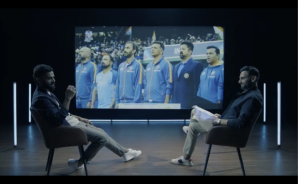 Virat Kohli is interviewed by Jatin Sapru as video of a cricket match is projected on screen in which you can see the controls that look similar to the ones in VLC media player.