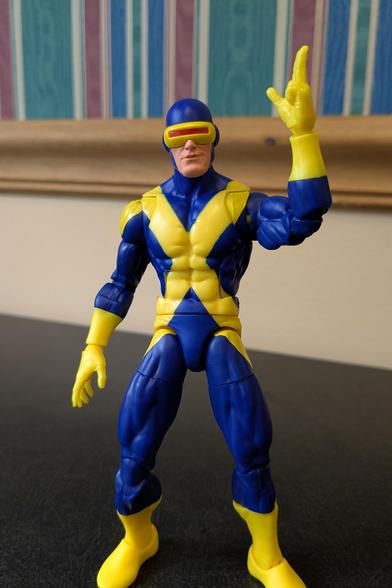 The Marvel Legends X-Men 97 Cyclops figure in a relaxed pose. His left hand is in a kind of finger gun pose pointed at the air, somewhat like the end of a relaxed salute.