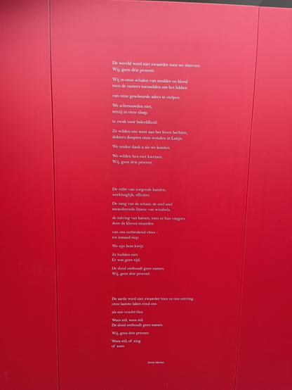 The image displays a vibrant red panel with a poem printed in white text. The poem is written in Dutch and it appears to be a reflective piece, perhaps dealing with themes of loss, human condition, or resilience. The repeated phrase “Wij, geen drie procent.” translates to "We, not three percent." This suggests a motif or a key concept within the poem, perhaps pertaining to a minority or a specific group underscoring their significance or insignificance in a larger context. The poem seems to evoke a deep emotional resonance and addresses serious subjects like death and identity.