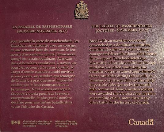 This image shows a bilingual plaque (in French and English) describing the Battle of Passchendaele, which occurred in October-November 1917 during World War I. The plaque outlines the harsh conditions and notable bravery demonstrated by Canadian forces during the battle. It mentions the challenging terrain and weather experienced by the soldiers, including deep mud and a dominating enemy force. Additionally, it highlights the significant casualties endured by the Canadian Corps and the awarding of the Victoria Cross to nine Canadian soldiers for their valor. The plaque is an official historical marker, as indicated by the logos of the Historic Sites and Monuments Board of Canada and the Commission des lieux et monuments historiques du Canada at the bottom. It seeks to commemorate this critical event in Canadian military history.