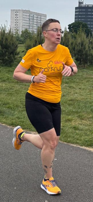Photo of Emily running. She is clearly straining. Her neck is tense and mouth is slack and downturned. Her eyes are almost closed and her cheeks are very red.