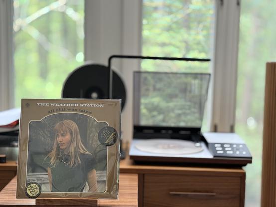 The Weather Station - All of It Was Mine LP cover.

In an arched inset, a color picture of Tamara Lindeman.

The white LP plays on a vintage, restored Bang & Olufsen Beogram 8002 linear-tracking turntable to the right.