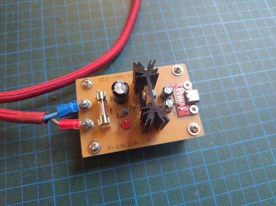 Another view of the PCB, showing the capacitors on the input side and a small USB-C breakout board soldered and screwed to the PCB. It also gives a good view of the "silkscreen" which has been plotted on using a pen plotter.
