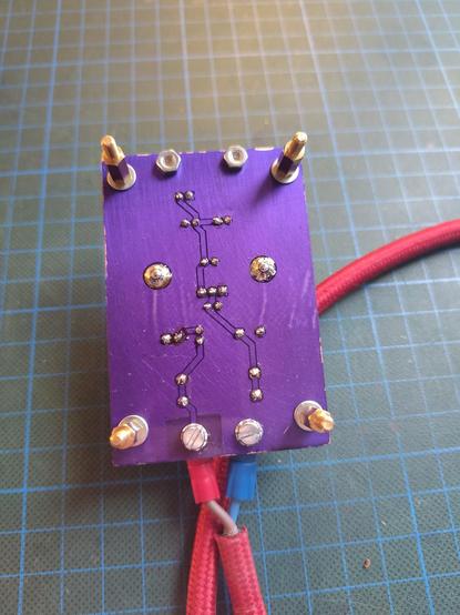 A view of the underside of the PCB, showing the traces, a large ground plane and a really cool looking purple solder mask.