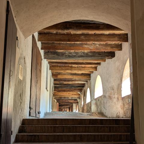 Scorcio della Via degli Asini, il caratteristico portico rialzato di Brisighella con le travi in legno e le finestre ad arco.