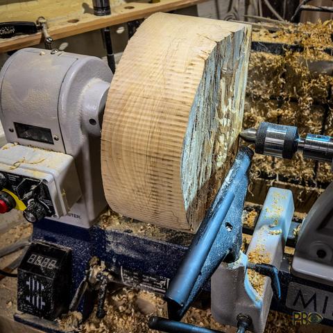 Photo of a woodworking lathe with a clamped blank ready to be turned down to shape.