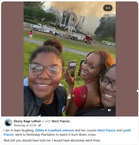 Three Black girls grinning, one with a bun and glasses and a black jacket, one with a red top holding two phones recording videos, and another one with glasses with half her face cut off the side of the picture, posing in front of the Nottoway Plantation as it burns. Facebook post text says:
"Ebony Rage Lathan is with Necii Francis.
Yesterday at 03:34  · 
I am in tears laughing. DrMia A Crawford-Johnson and her cousins Necii Francis and Lynell Francis  went to Nottoway Plantation to watch it burn down. Lmao 
Real shit you should have told me. I would have absolutely went lmao."