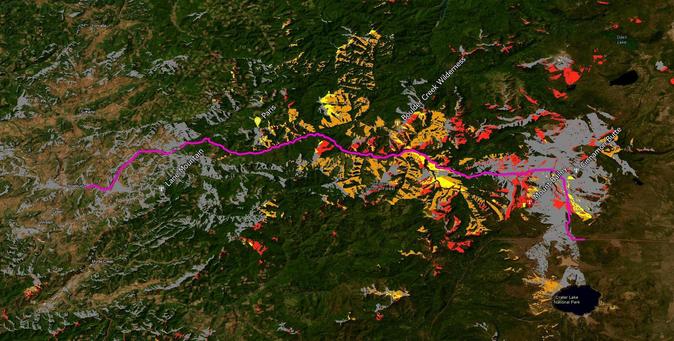 A topographic map showing the terrain of an area in Oregon, with various colors indicating different land types and features, including forested regions and mountainous terrain. A pink line traces a route across the landscape, with notable landmarks labeled, such as Roseburg.