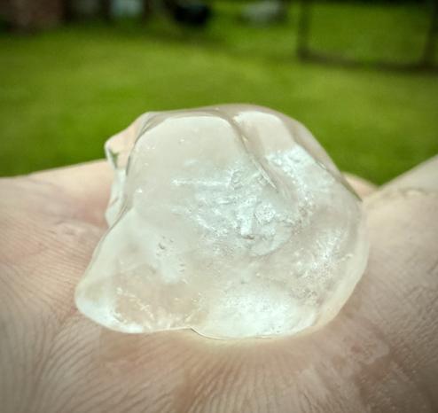 Hunk of hail out of lawn held in hand