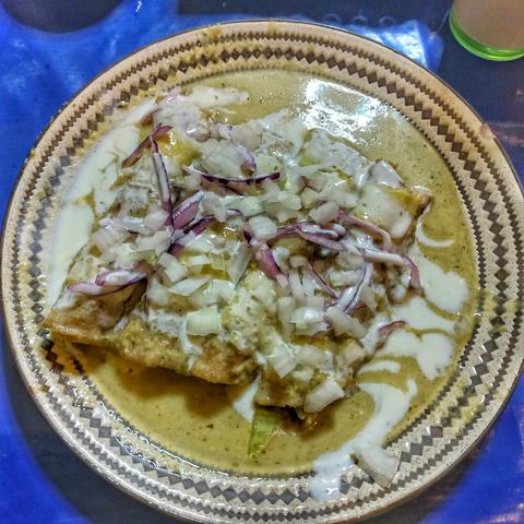 enchiladas meal made with cheese, onion, chicken and green sauce.