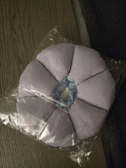 Plush "collar of shame" in the form of six petal segments surrounding a hole in the middle.