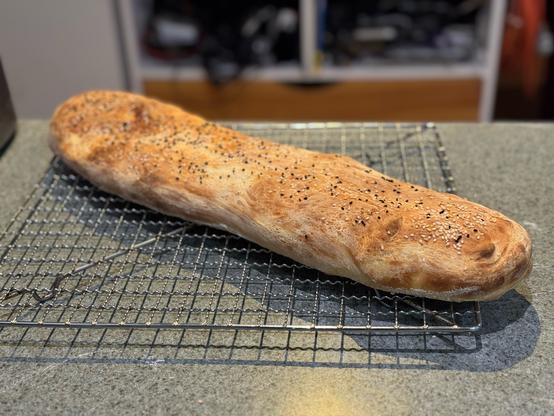 A long, wide, low loaf with nigella and sesame seeds on top.