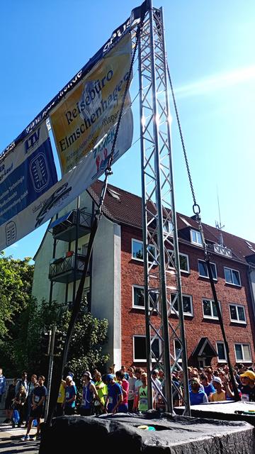Das Starttor des Fischhallenlaufes in Kiel. Viele Läuferinnen und Läufer warten auf das Startsignal.