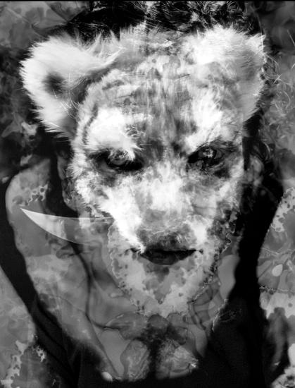 Black and white photograph, portrait format, multiple exposure, self-portrait (headshot). Woman looking up into the camera, double-exposed with a person masked as a tiger, holding a pointed, curved knife between her teeth. Overall impression: a chimera of human and animal, wild, but only dangerous if provoked. Ready to defend itself.