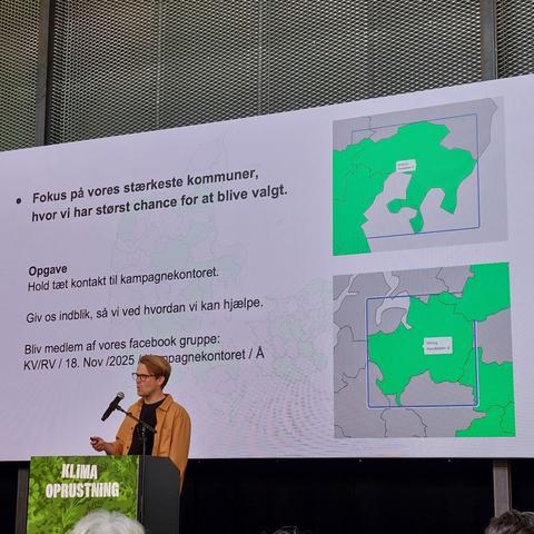Toke Lotz taler. 

På baggrundsskærmen er der 2 billeder. Et af Syddjurs kommune hvor Alternativet har 8 kandidater, og et af Viborg kommune hvor Alternativet har 9 kandidater. 

Teksten på skærmen siger:
* Fokus på vores stærkeste kommuner, hvor vi har størst chance for at blive valgt. 

Opgave
Hold tæt kontakt til kampagnekontoret.

Giv os indblik, så vi ved hvor vi kan hjælpe. 

Bliv medlem af vores Facebook gruppe: 
KV/RV / 18. Nov /2025 / Kampagnekontoret / Å.