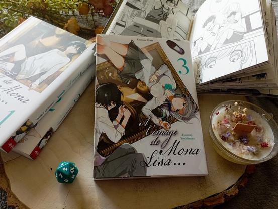 Une photo du livre À l’image de Mona Lisa, tome 3, de Tsumuji Yoshimura entouré d’objets de décoration.