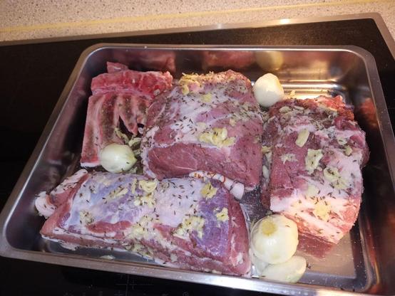 photo of a lot of meat seasoned with salt garlic and karaway seeds with some onions