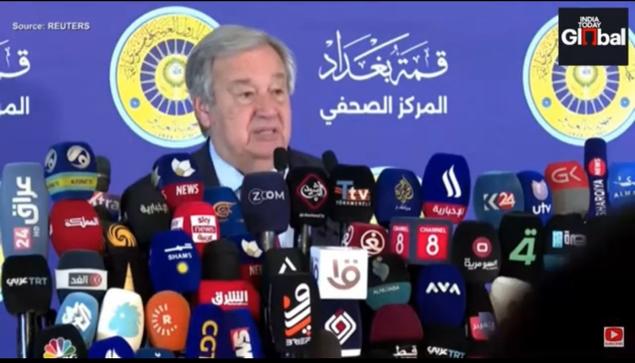 United Nations Secretary-General Antonio Guterres, addressing the media, surrounded by numerous microphones from various news outlets.