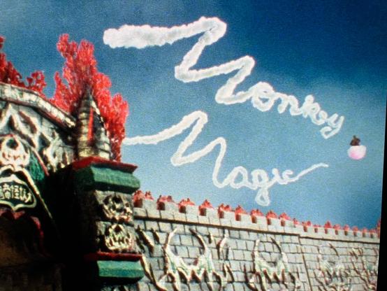 Shot of the TV series Monkey. A castle wall is visible in the lower section. In the sky, written with a magic cloud is Monkey Magic.